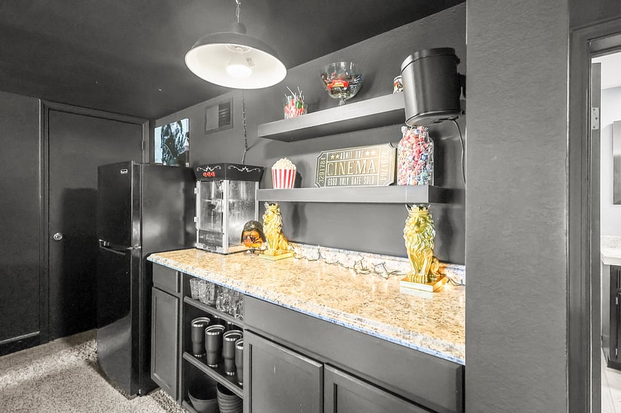Movie room counter with popcorn machine and medium size fridge