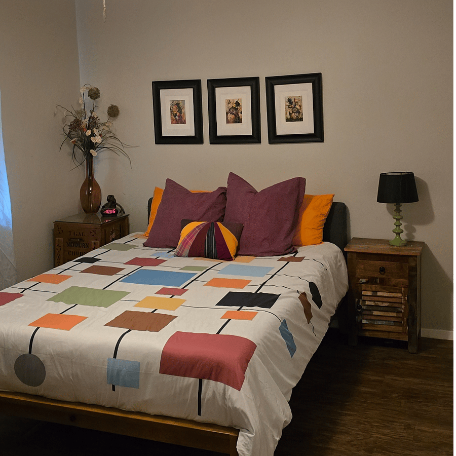 Primary bedroom has a queen bed and double closet. There are blinds and blackout curtains on the window.