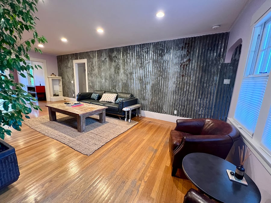 Corrugated metal accent wall gives the living room modern appeal.