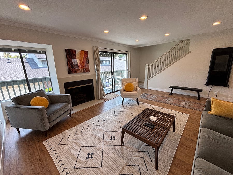 Living room looking at fireplace, slider to balcony, and stairway
