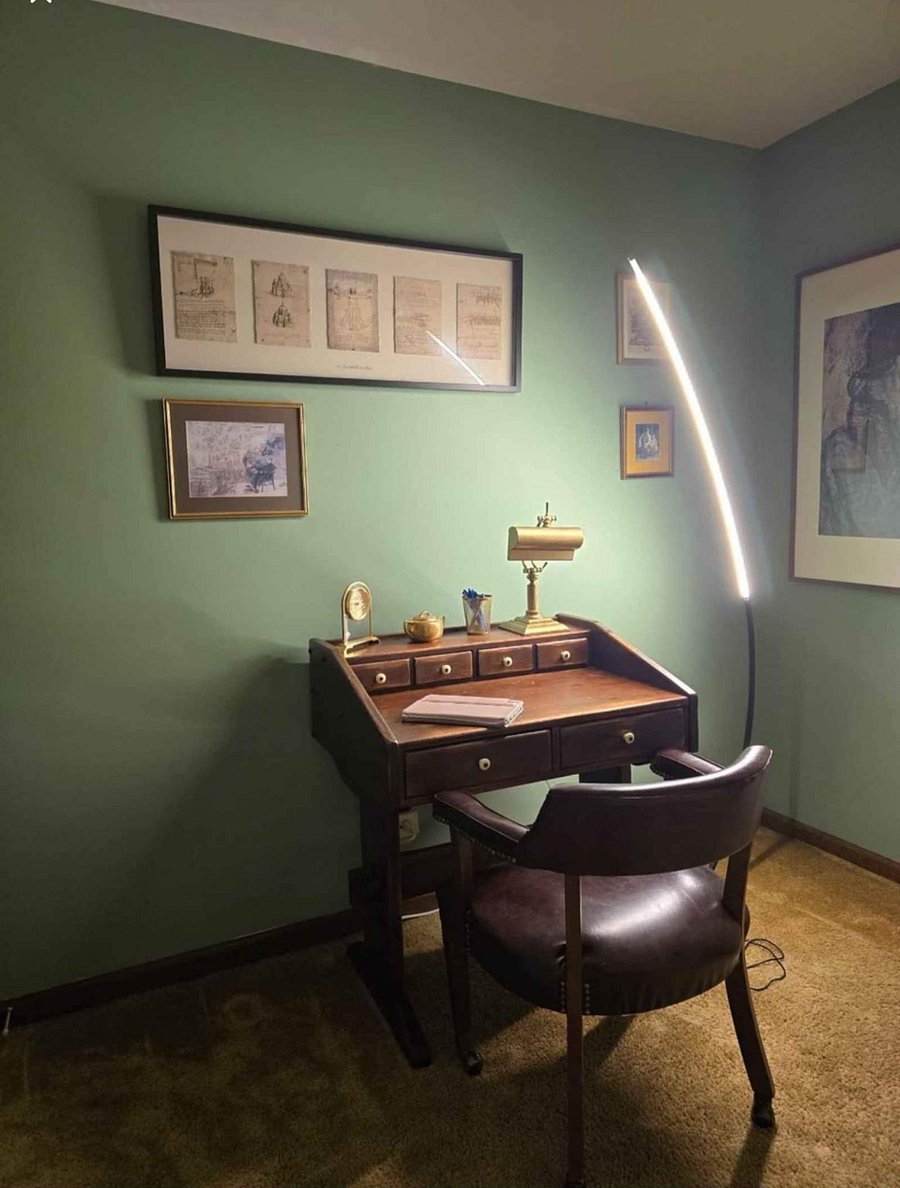 Work corner with a classic wooden desk and good lighting, ideal for laptop use or writing.