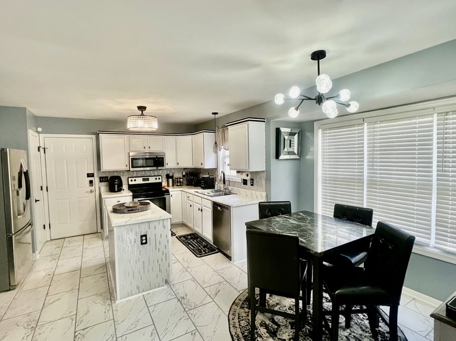 A full kitchen area with a table that seats for as well as a TV to enjoy while cooking.