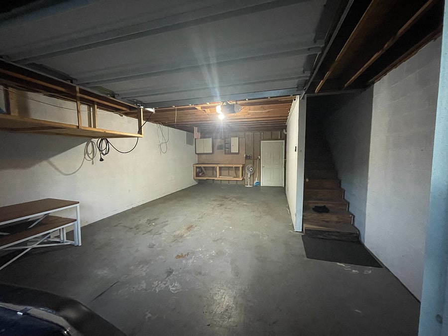 empty garage with stairs to living room.