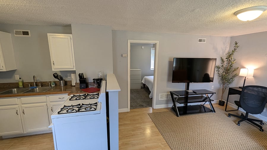 The door in the center is your bedroom. To the left is the fully equipped kitchen and your living space and desk are to the right!