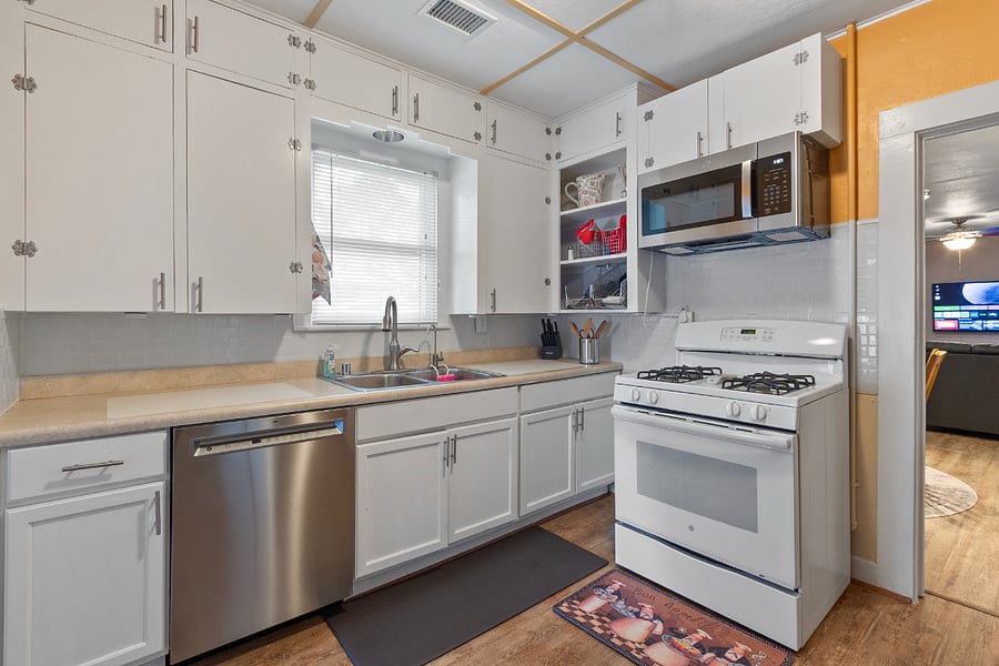 Gas stove with cooking utensils nearby. Over the range oven.