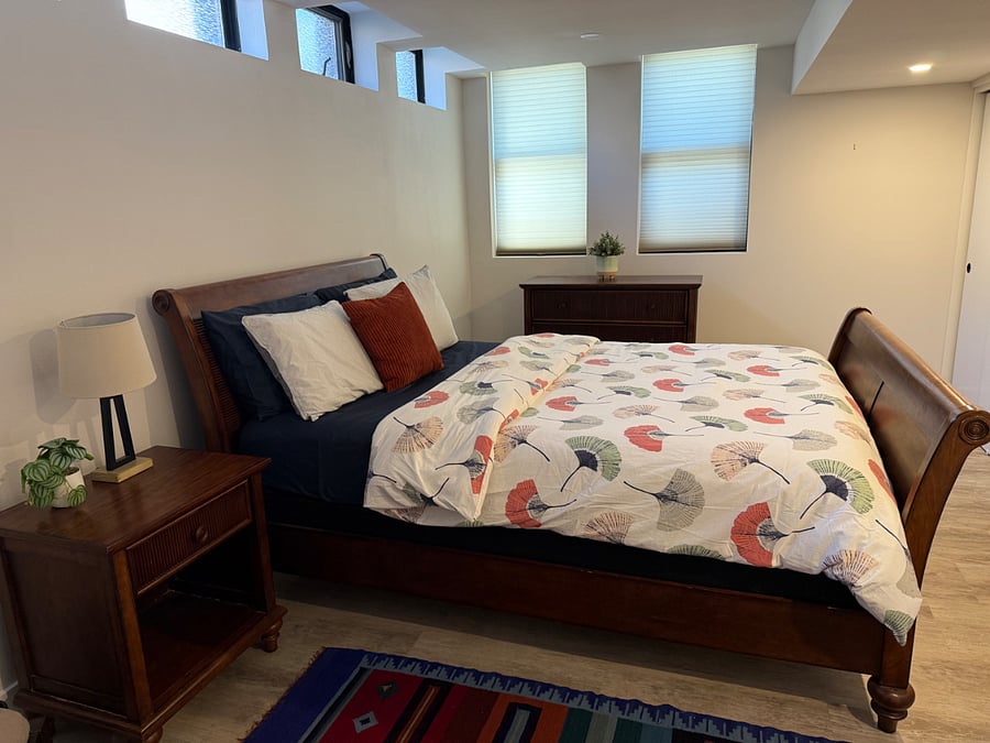 queen bed with nightstand lamp, and chest of drawers. 
