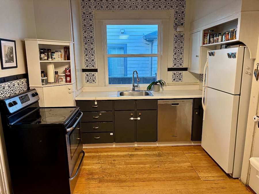Shared lower-level kitchen connected to the laundry room, with oven/stove, fridge/freezer, and dishwasher.