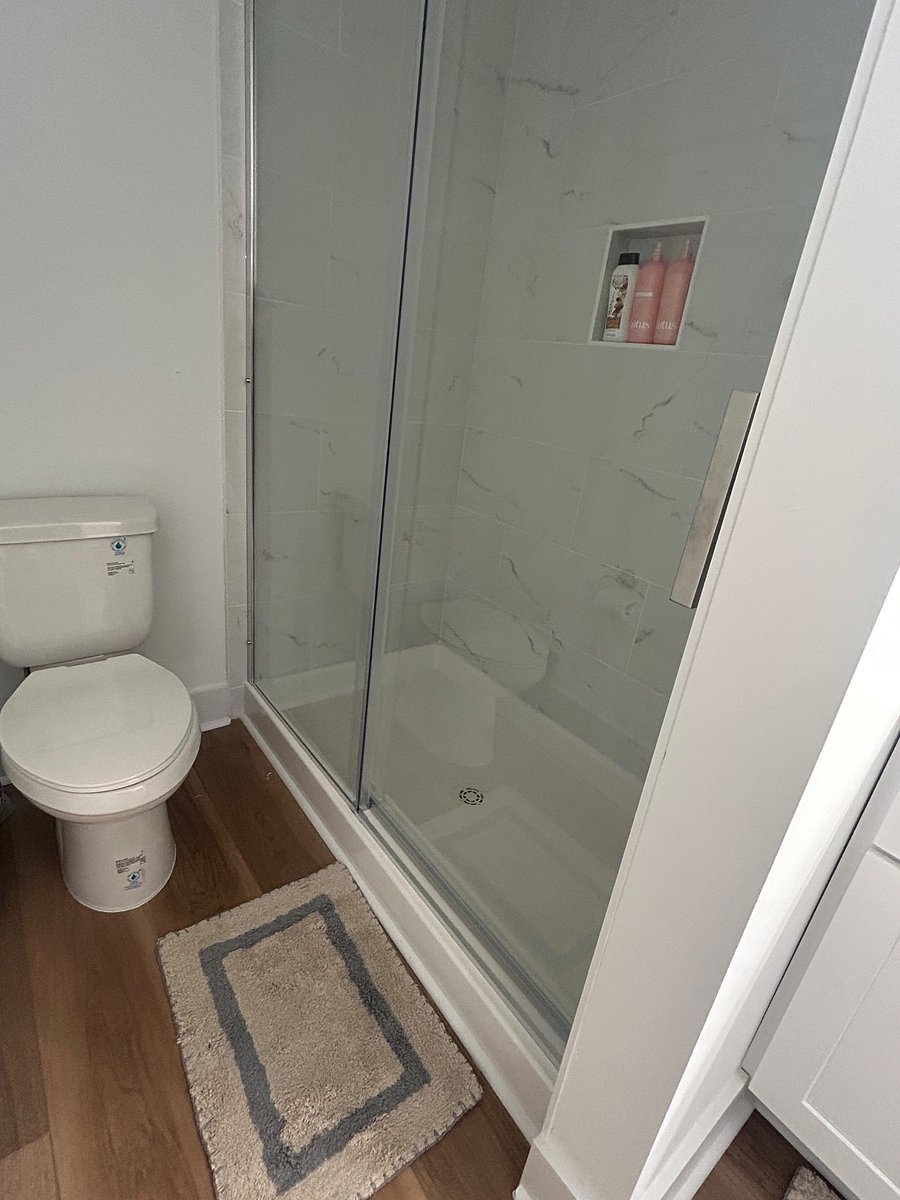 Mster bath tile shower has glass sliding door 