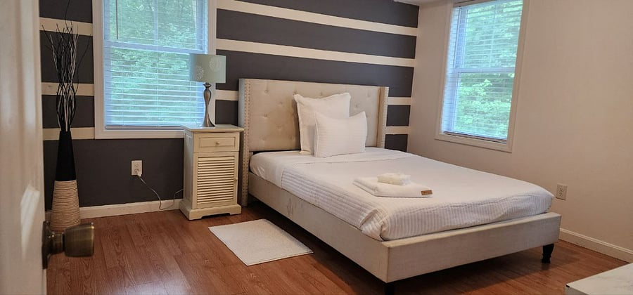 Bright furnished room with cozy bedding & ample storage