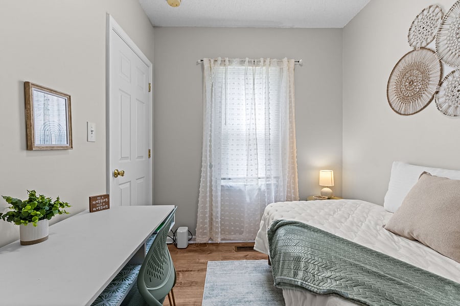 The second bedroom offers cozy living space with a hybrid twin mattress and a functional work space.