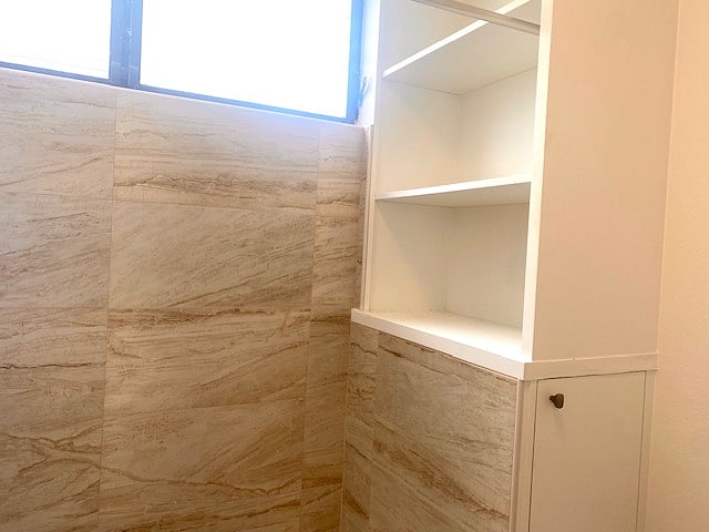 Built-in for shower toiletries and towels. Also, built in has storage space under the shelving area accessible from the bathroom.