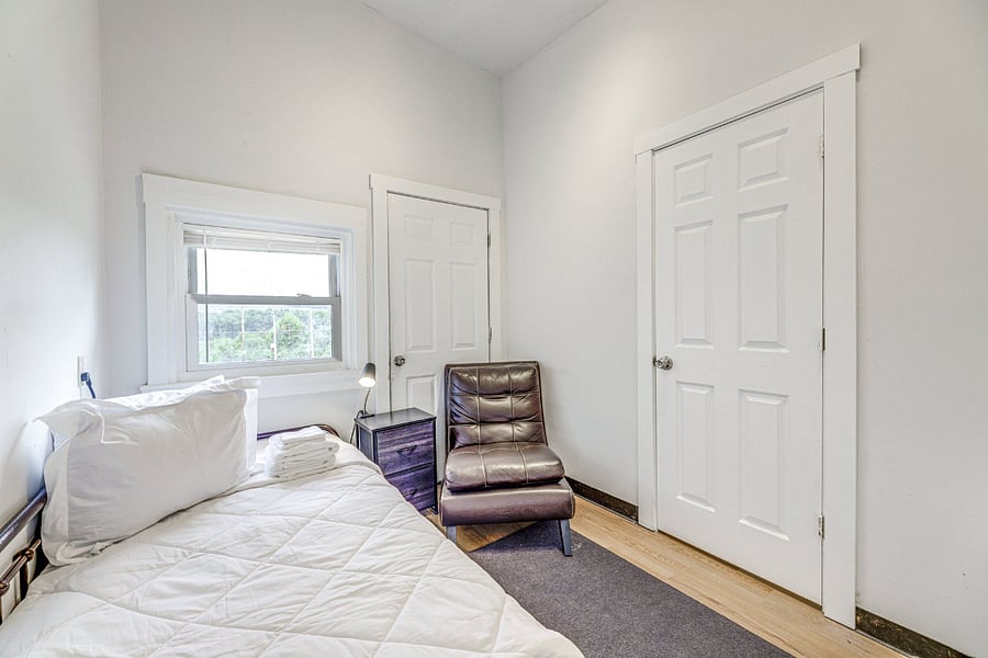 Private room with single twin bed and attached private bathroom.