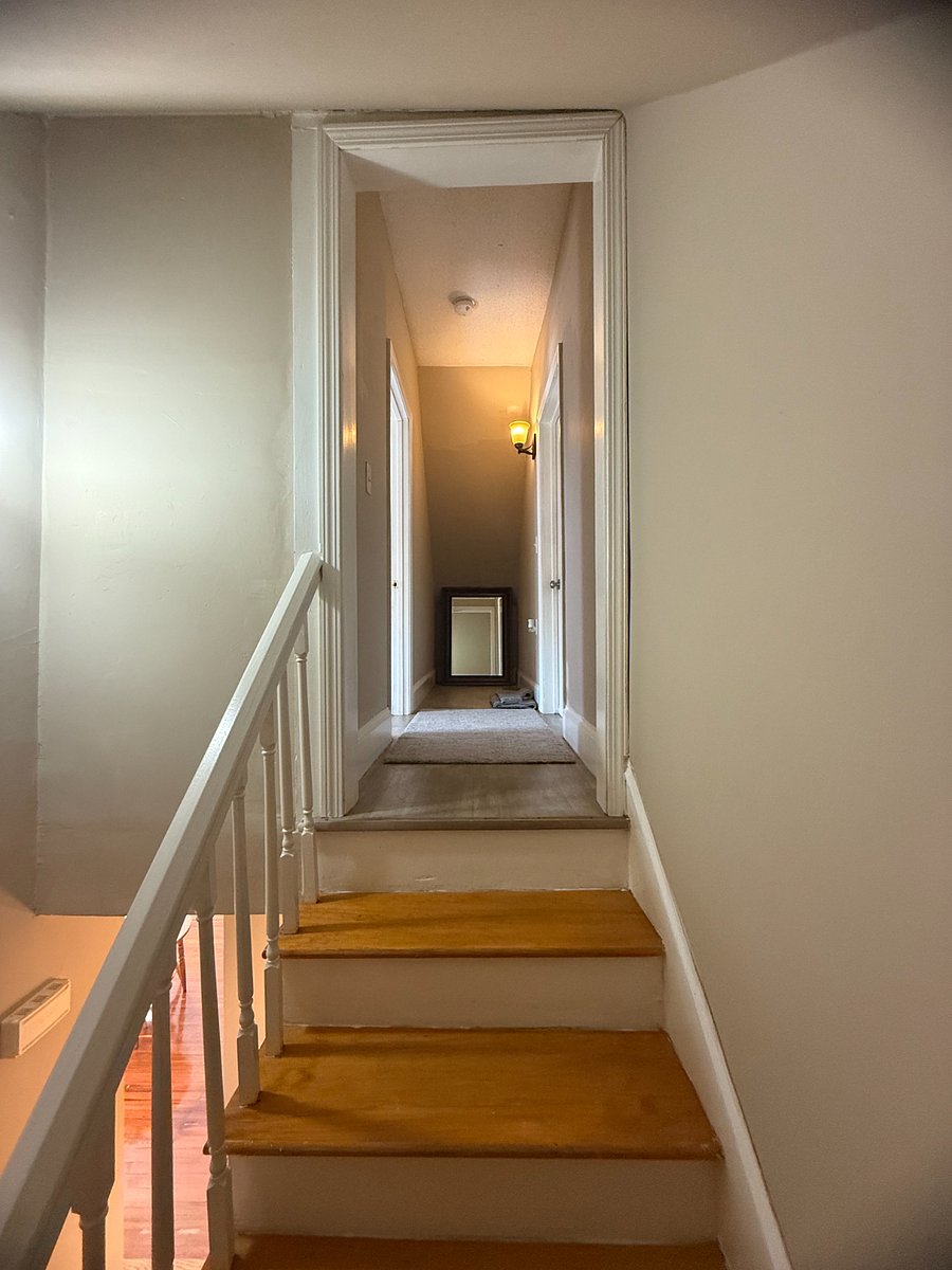 Hallway leading up to the third level bedroom on the left.