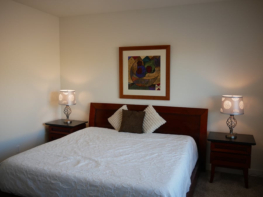 The primary bedroom has a king sized bed, tv and ceiling fan. 