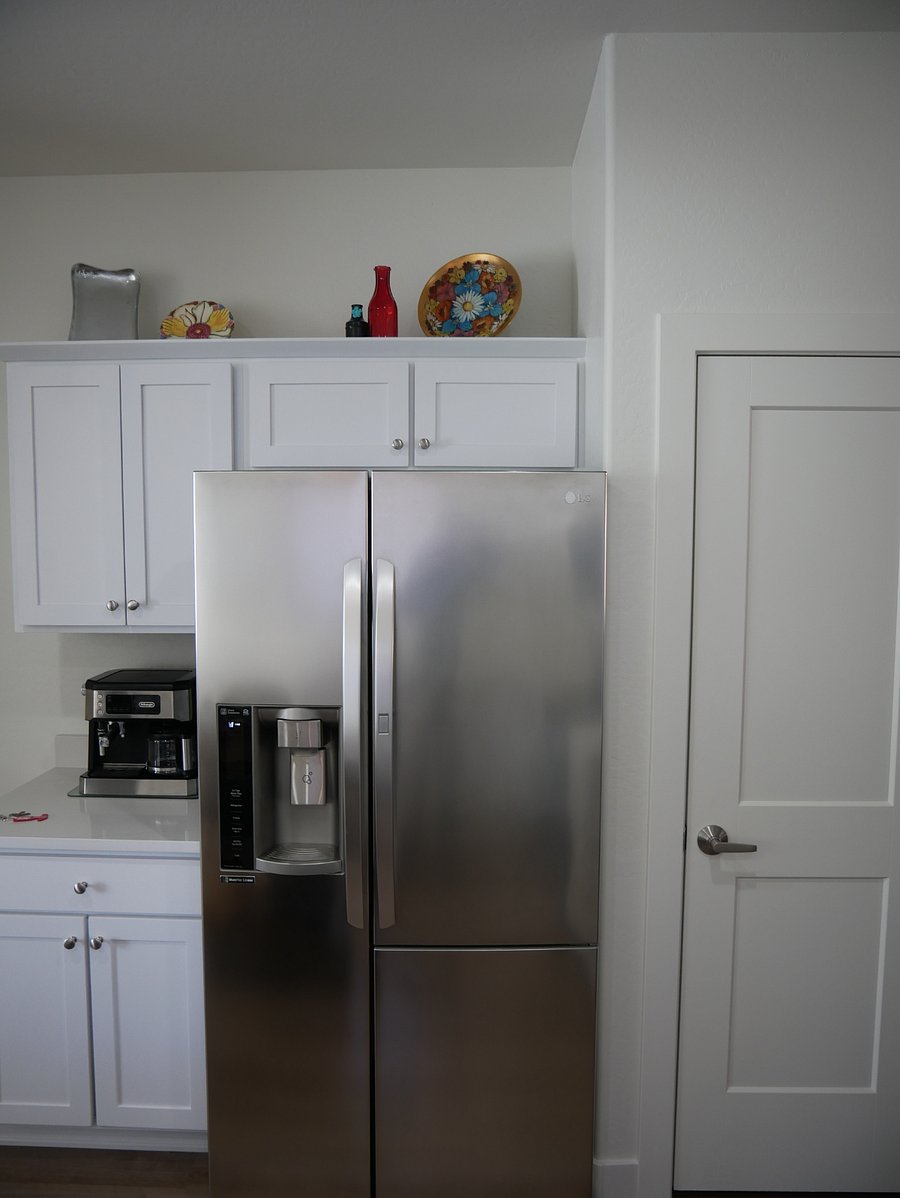 Kitchen is equipped with newer appliances and a De'Longhi coffee maker. 