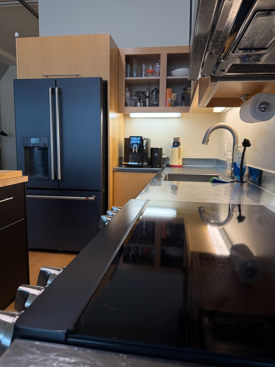 GE Cafe modern appliances include an induction stove and ice maker on the fridge. There is also a touchless faucet.