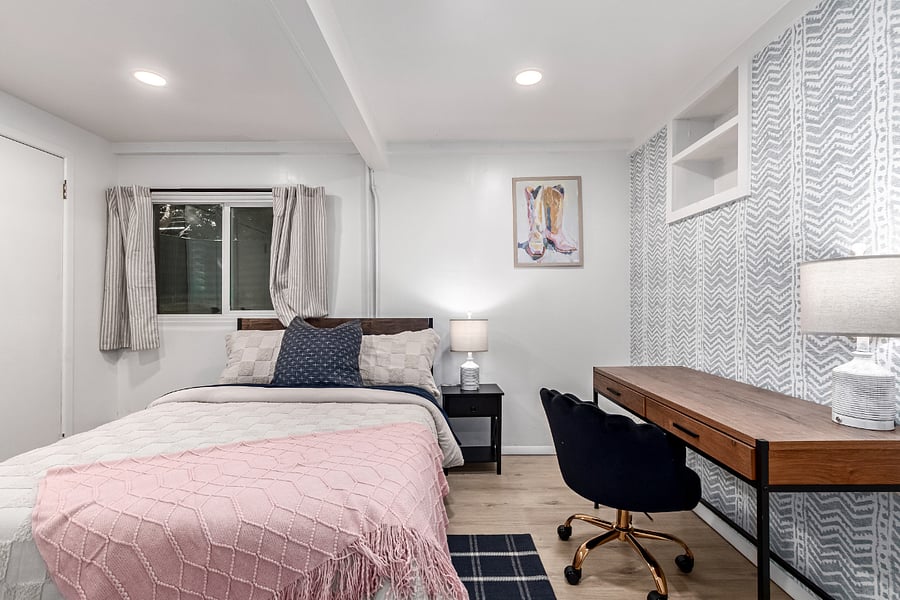 Western-inspired Bedroom. Features full-size bed, dedicated workspace with desk, and western-chic artwork. Ideal for travel professionals or remote work stays. 