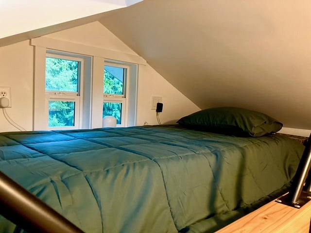 Cozy sleeping loft with a nice view and extra storage space.