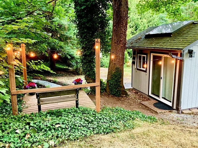 Charming, private deck with a bench and a view of the forest.