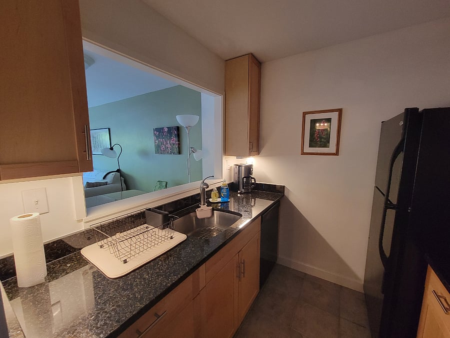 Galley kitchen of granite and maple cabinetry.