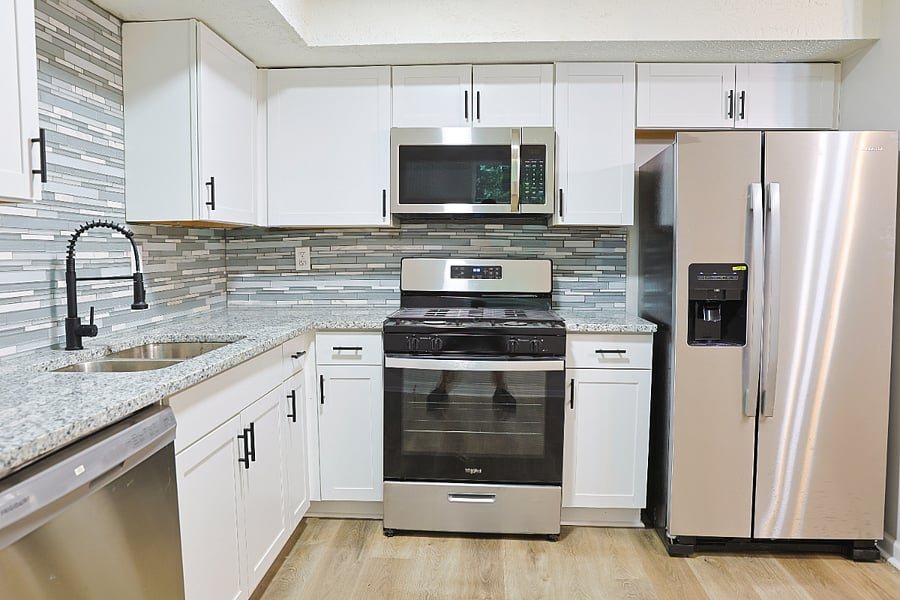 Fully stocked shared kitchen with granite countertops and stainless steel appliances.
