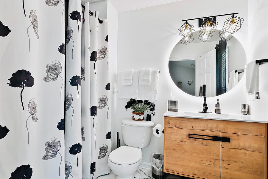 Newly renovated master bath exudes modern elegance w a sleek, minimalist design. Featuring large floor marble tile contrasted by matte black fixtures for a bold, contemporary touch. Complemented by LED backlit mirror & accessories for a spa feel.