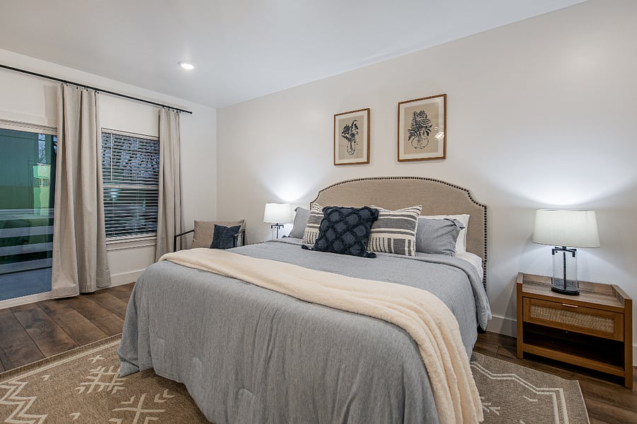 Spread out in the spacious master bedroom. This room features a luxury hybrid king bed, accent chairs, an alarm clock, sound machine, desk, and black out curtins. Hangers and luggage racks are included in the closet.