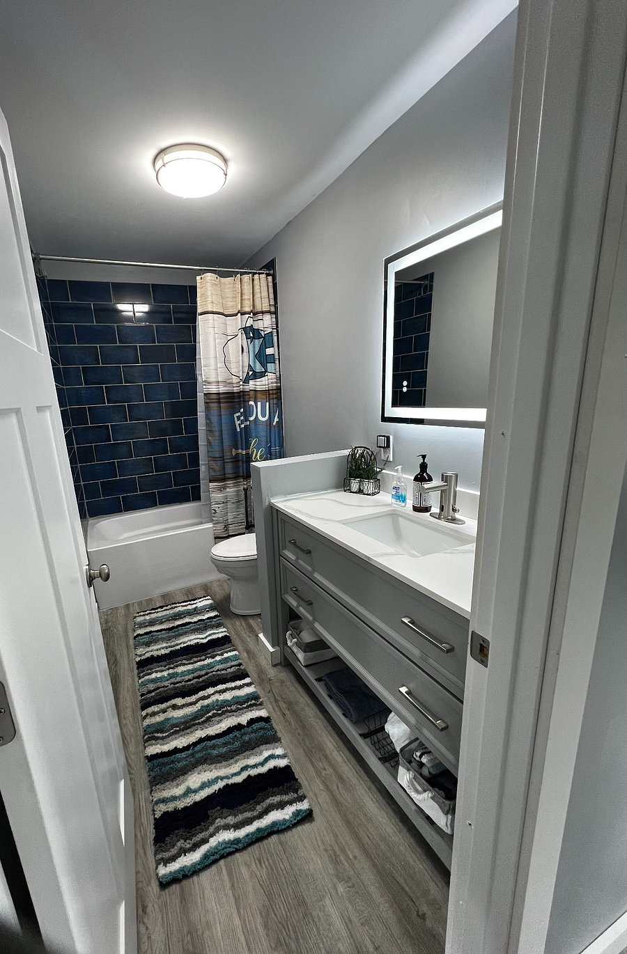 Full bath with tile shower and anti-fog lighted vanity mirror