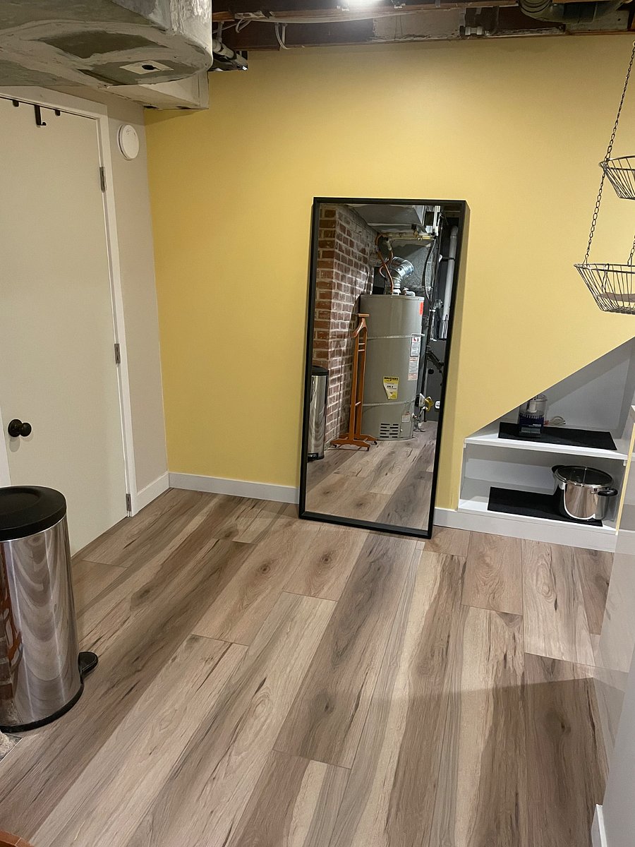 Hot water tank and furnace are outside the bathroom. Large mirror next to kitchenette