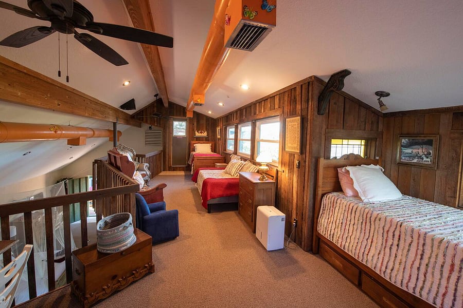 Upstairs sleeping loft. Fans, desk, and three twin beds.