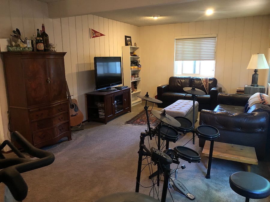 Additional family room (AKA The Rumpus Room). Two couches, TV, book shelf with board games, electronic drum set, stationary exercise bike. Door which closes this room off from rest of house. Sliding glass doors to backyard.