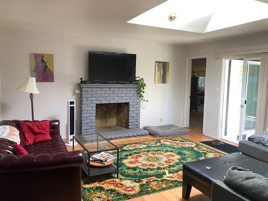 Main living room. Two couches (one is a large "L"), two coffee tables, large smart TV.