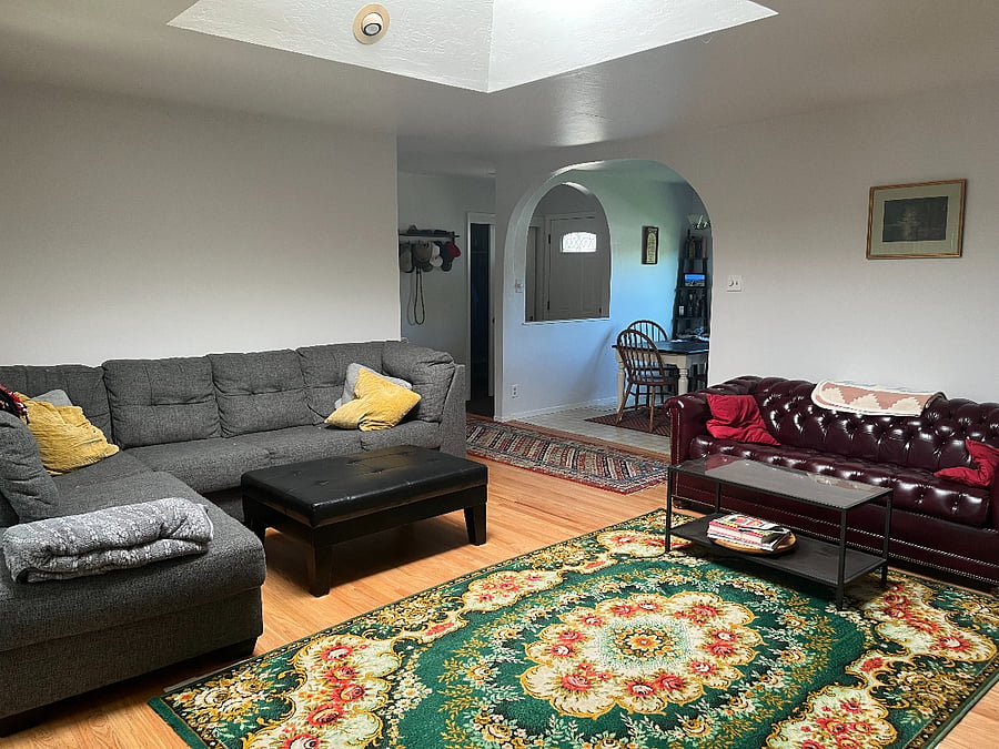 Main living room. Two couches (one is a large "L"), two coffee tables, large smart TV.