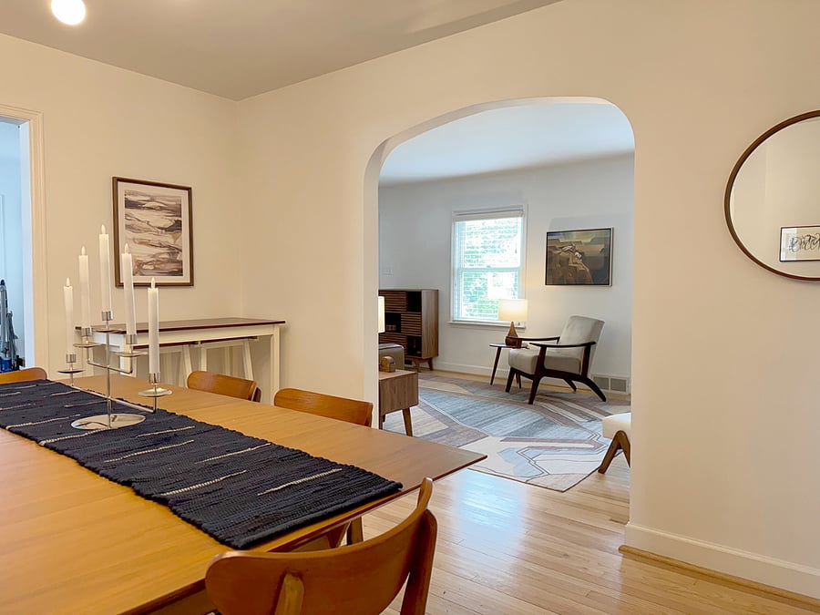 View from Dining Room to Living Room showing dining table and bar with two stools