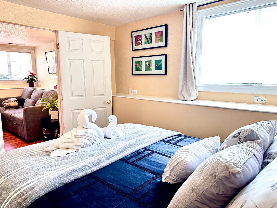 Bedroom 1 features a queen-size bed with comfortable, hotel-grade bedding and a closet with hangers.