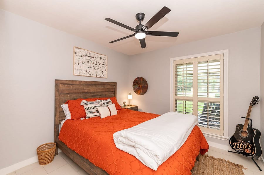-Sleep soundly in this charming queen suite featuring warm tones, a ceiling fan, and natural light. -Stylish decor and premium linens create a welcoming, restful vibe. -Enjoy guitar-inspired Texas charm and backyard views cozy and unique.