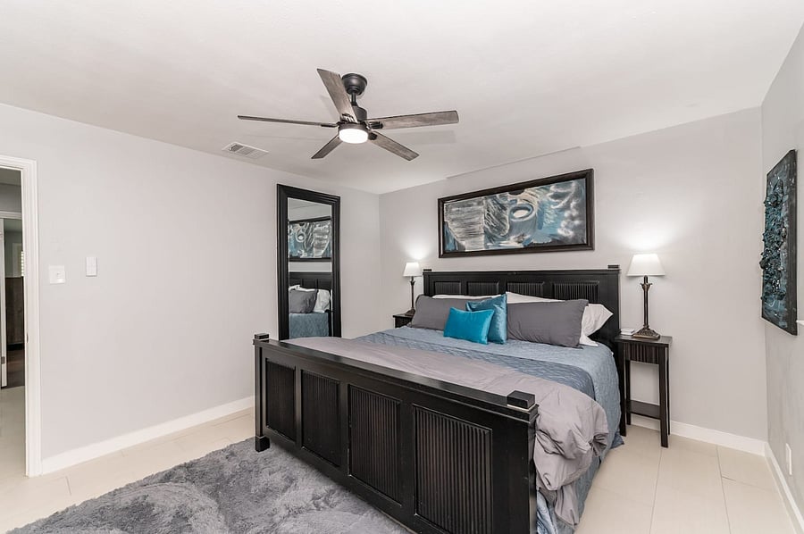 -Stylish and serene king suite with plush bedding, modern decor, and calming gray tones. -Equipped with a ceiling fan, bedside lighting, and a full-length mirror for added comfort and function. -Spacious layout perfect for couples or solo travelers.