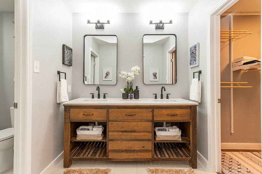 Double sinks, open shelving, and warm wood tones create a clean and cozy space for guests to share. Thoughtfully stocked with fresh towels, toiletries, and thoughtful touches to make mornings easy.