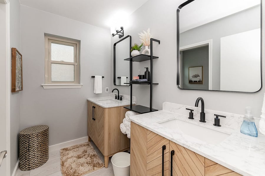 Enjoy a spa-inspired space featuring double vanities, black matte fixtures, and plenty of counter space for group stays. Soft towels, starter amenities, and stylish lighting make this bathroom both functional and relaxing.