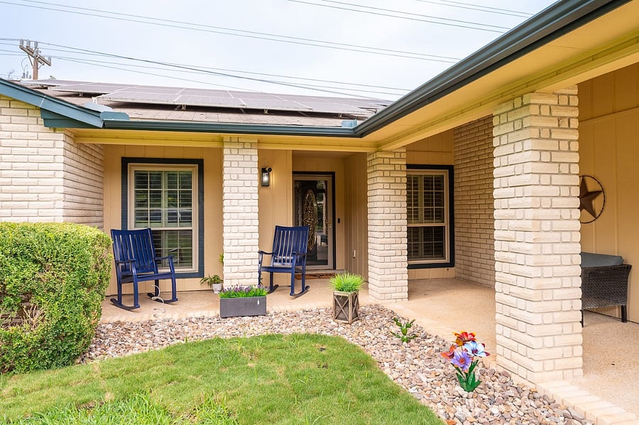 Charming curb appeal with covered porch and cozy seating perfect for morning coffee or evening relaxation.