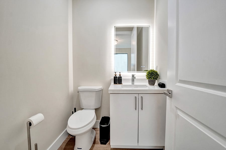 The convenient half bath has a vanity and a clean, minimalist design.