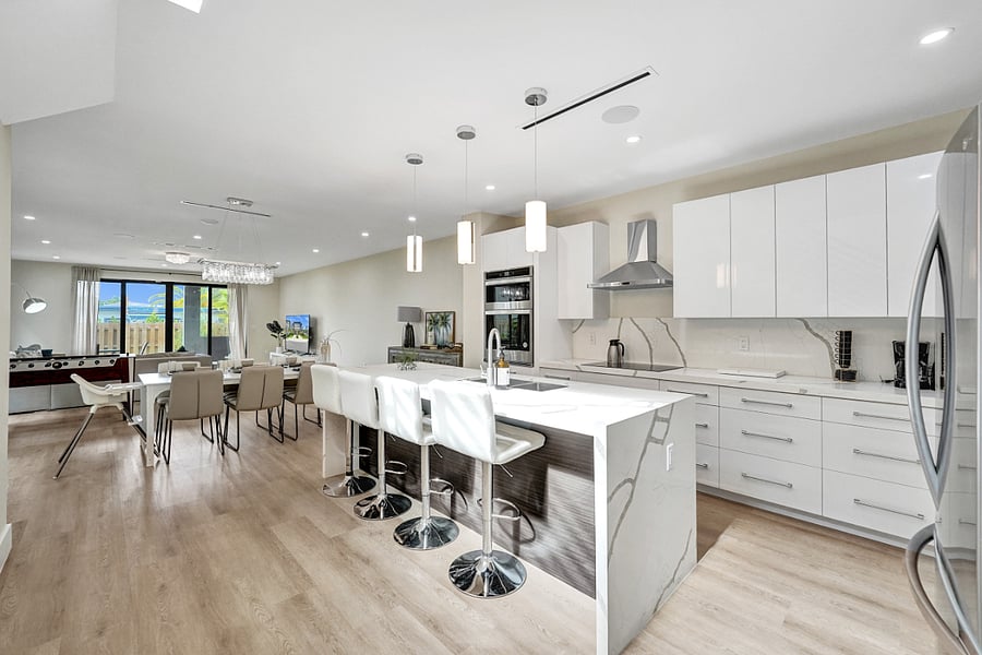 Relax in the stylish open-concept living area, featuring a fully equipped kitchen, adjacent dining area, and a living area with modern decor designed for ultimate comfort.