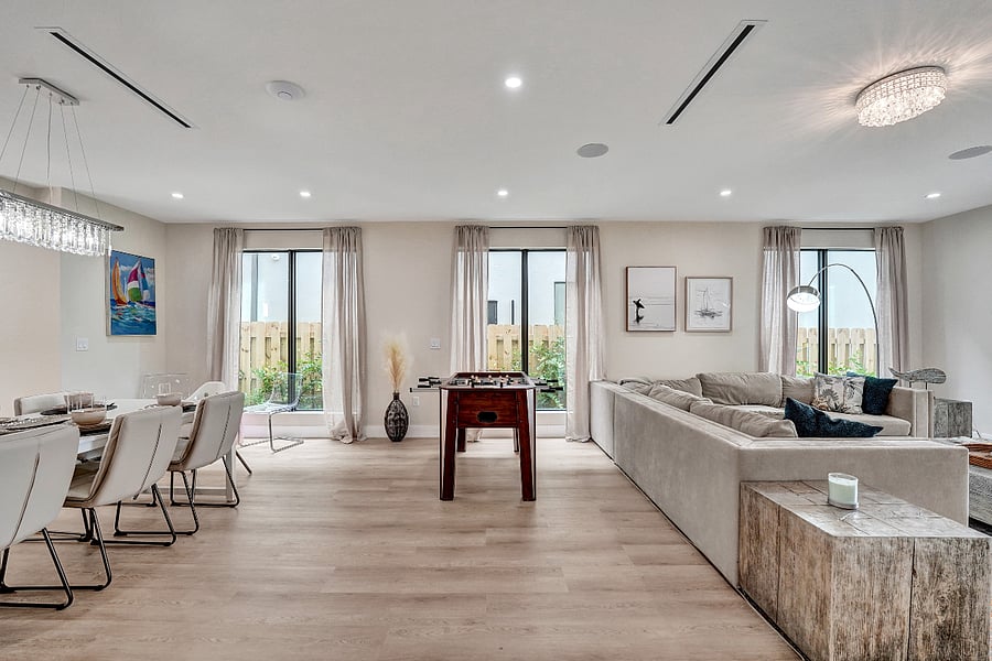 A bright, airy space with natural light pouring through large floor-to-ceiling windows creates a welcoming ambiance.