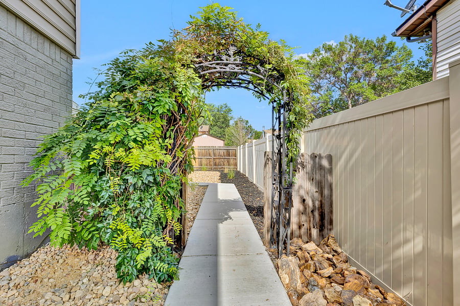Beautiful wisteria trellis leading to the home's entrance.