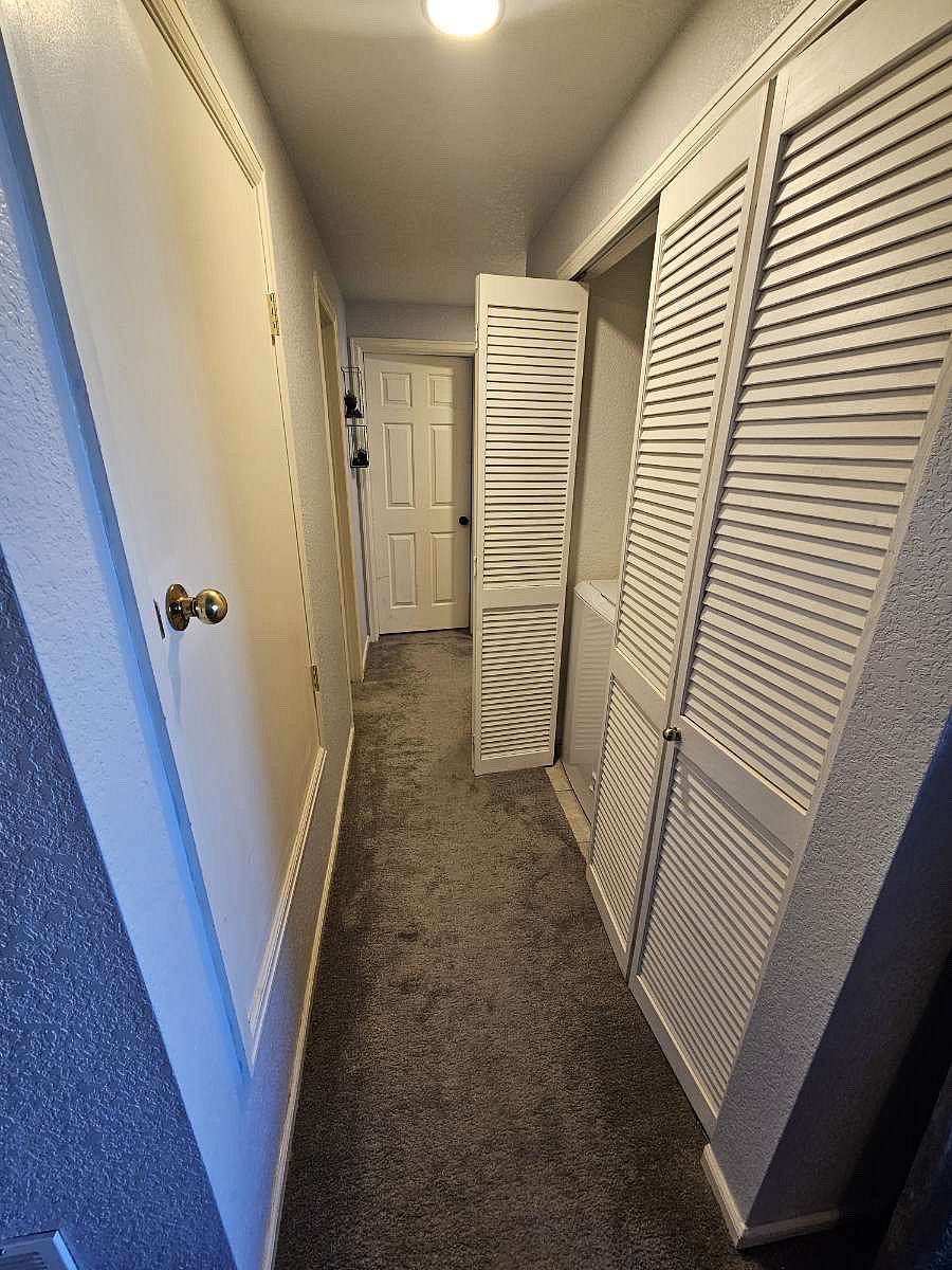 Hallway to bedrooms/bathrooms featuring in-unit washer and dryer