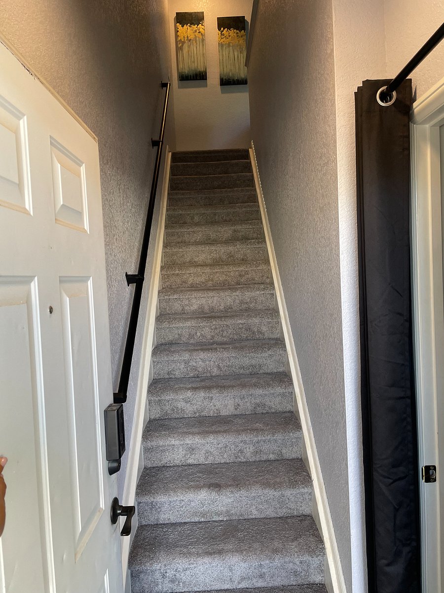 Front door is located on the first floor with steps leading up to the living area. Hand rail for safety and coat closet for storage