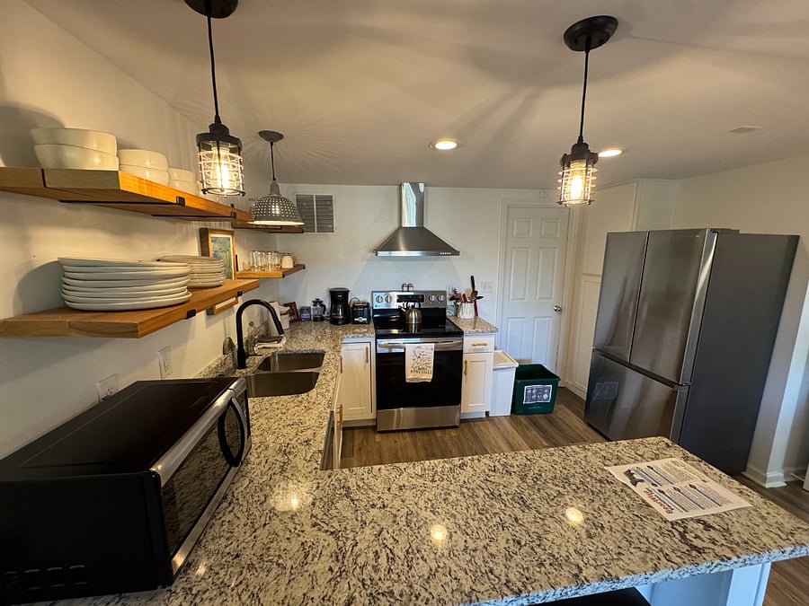 Your kitchen has a full-size stainless steel French-door refrigerator, a glass-top range, and accent lighting over sink and dining area.