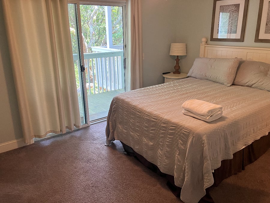 Master bedroom with queen bed and sliding glass door to back porch
