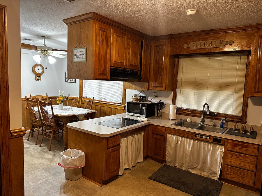 View of kitchen and smaller eating area. The stove is set slightly lower to accommodate wheel chair accessibility.  