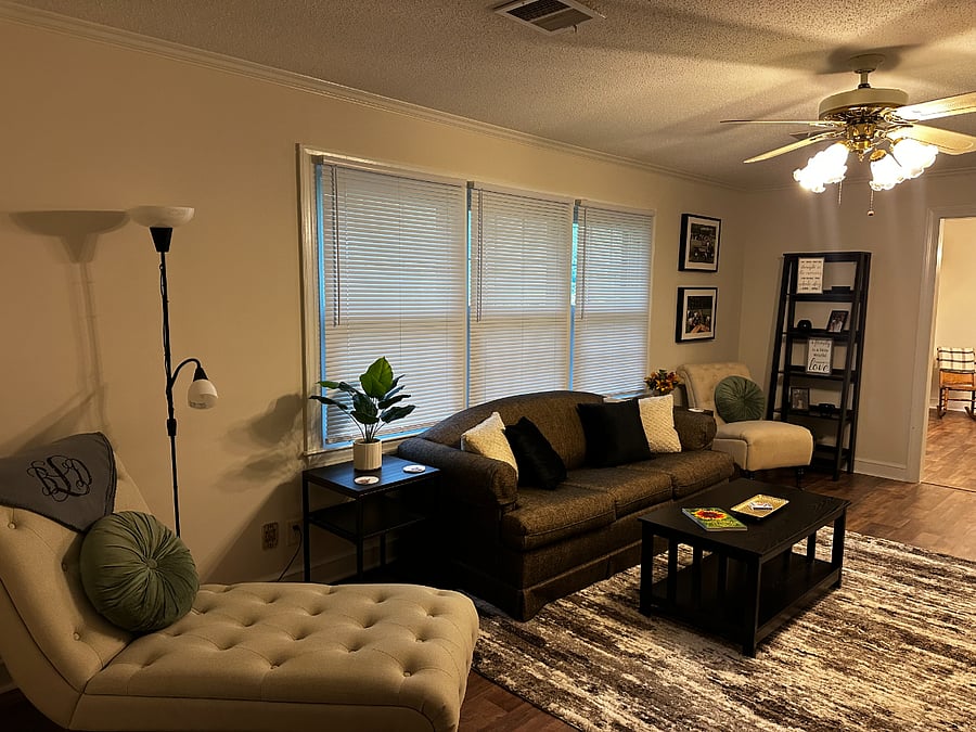 Another view of the living room featuring a comfy sleeper sofa and quiet seating for reading and fellowshipping